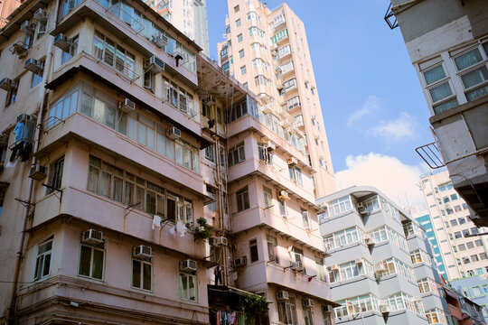 Cluster of urban residential buildings under a clear blue sky in a bustling city area. Hongkong, China