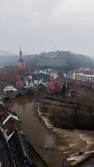 Fototapeta premium Breathtaking drone panorama of Bad Kreuznach's landmark bridge houses in winter. Traditional half-timbered facades reflected in the high water of the Nahe river at dusk.