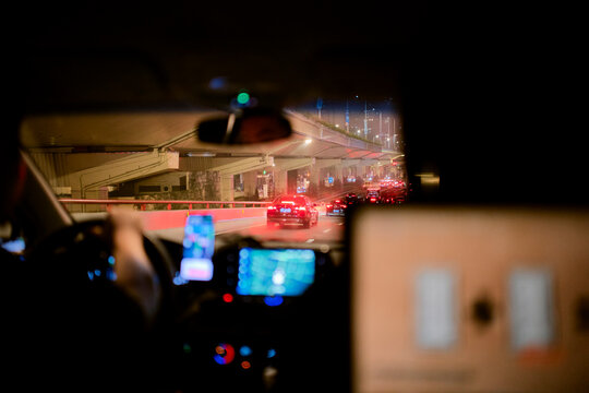 Night-time city drive with illuminated highway and car lights visible through windshield. Shanghai, China