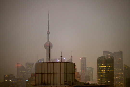 Shanghai skyline with Oriental Pearl Tower shrouded in smog during dusk. Shanghai, China