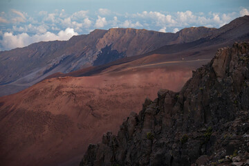 Rugged volcanic landscape with rocky ridges under a cloudy sky at dusk. Kula, Hawaii, USA