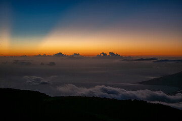 Stunning sunrise over a serene landscape with misty clouds and vivid colors. Kula, Hawaii, USA
