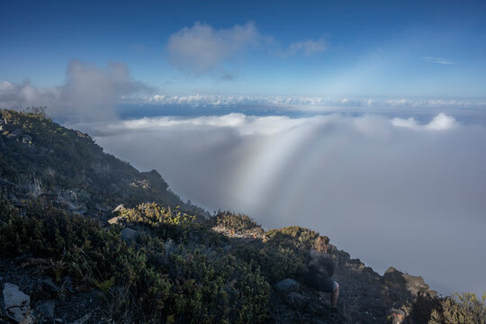 Mountain landscape with clouds and a rainbow-like light effect against a blue sky. Kula, Hawaii, USA