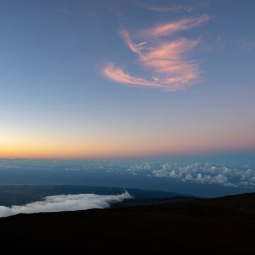Twilight sky with pink clouds over a tranquil horizon and rolling landscape. Kula, Hawaii, USA