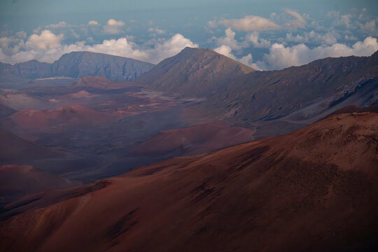 Expansive view of rugged mountains and valleys under a cloudy sky during sunset. Kula, Hawaii, USA