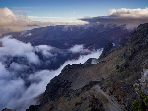 Dramatic mountain landscape with rocky cliffs and swirling clouds under a dynamic sky. Kula, Hawaii, USA