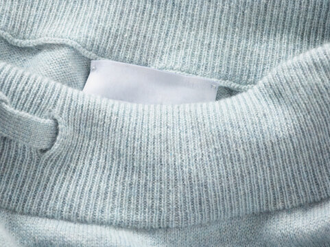 Close-up of a light blue sweatshirt with a tied drawstring on a ribbed waistband.