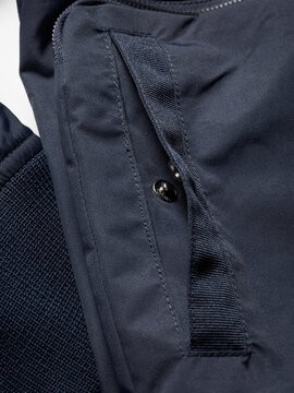 Close-up of a blue textile fabric with a zipped pocket and textured material.