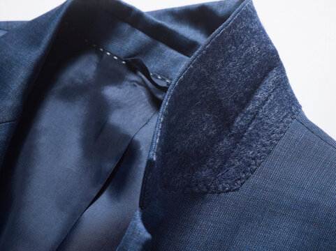 Close-up of a blue suit jacket collar with a smooth inner lining.