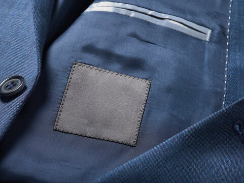 Close-up of a tailored blue suit jacket with a black fabric patch inside.