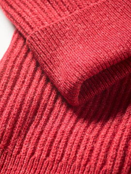 Close-up of folded red knitted fabric with vertical ribbed texture.