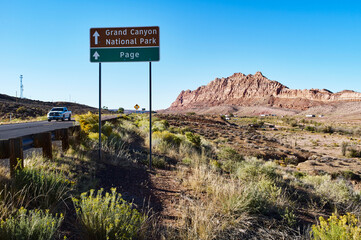 Road leading to Grand Canyon National Park with a clear blue sky and rugged desert landscape. USA