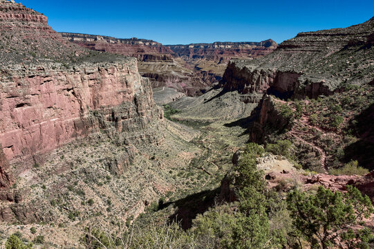 Majestic canyon view with rugged cliffs under a clear blue sky in a vast desert landscape. USA