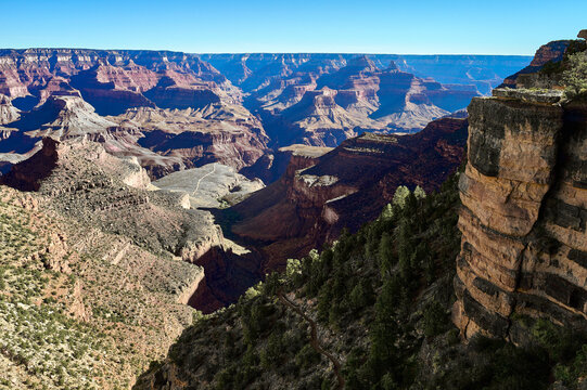 Grand Canyon landscape with vast cliffs and deep valleys under a clear blue sky. USA