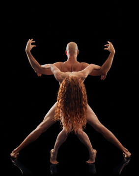 Two intertwined dancers forming a striking artistic pose against a black background. WA, USA