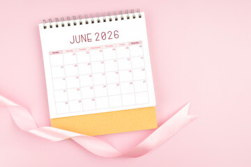 June 2026 desk calendar with pink pastel ribbon.