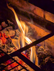 Flame wood in bonfire. Camp barbecue wood charcoal burns in the grill. Blaze fire flame texture background. Tongues of flame. burning wooden logs and large orange flame. Glowing Firewood campfire.