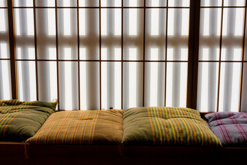 障子越しの光と並んだ色とりどりの座布団