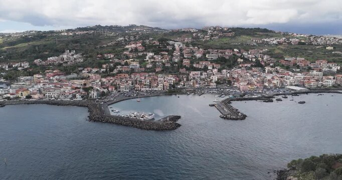 Aerial view of the charming coastal town and harbor of Aci Trezza, where the deep blue sea meets the quaint seaside village, Aci Trezza, Sicily, Italy.