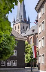 Obraz premium a densely built European street with vintage old buildings and a tall spire 