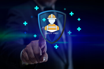 Businessman touching on virtual screen safety icons with helmet, Safety first concept, protection symbols representing workplace safety, accident prevention, industrial safety responsibility concept