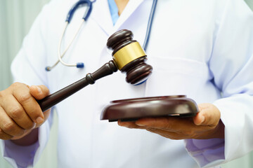 Asian doctor holding court hammer for and crime law justice, forensic medicine.