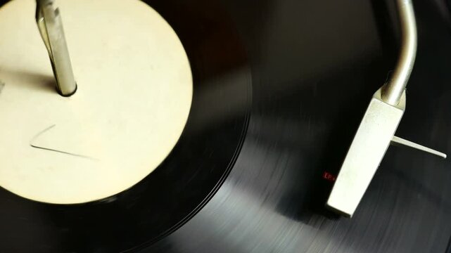 Vinyl record spinning on a classic turntable. White label and stylus head. Music album spinning with the needle cartridge.