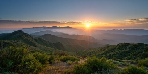 Obraz premium Breathtaking sunrise over rolling hills and misty mountains