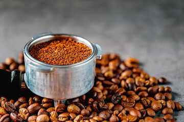 Ground coffee in portafilter or coffee ground in portable filter handle and coffee beans, Close-up