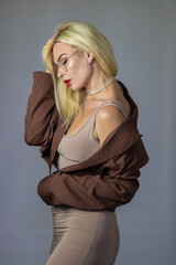 Fototapeta premium Elegant side portrait of blonde woman with glasses and draped blazer