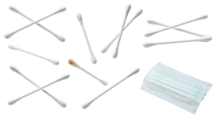 Scattered white cotton swabs with one earwax-stained tip beside a folded disposable surgical face mask on a transparent background