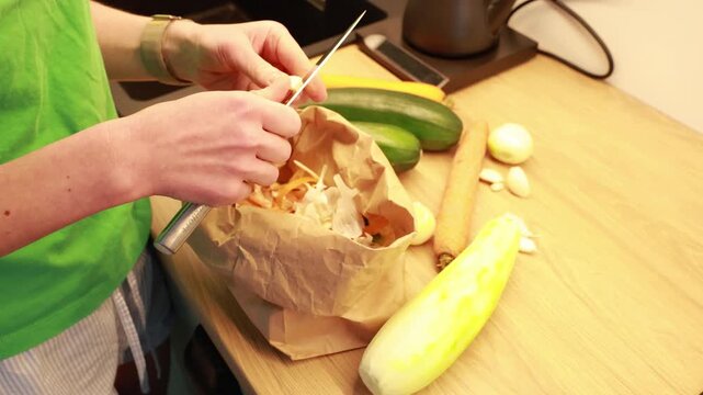 Hands peeling garlic with a knife in a home kitchen.