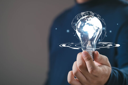 Hand holding glowing light bulb with world map inside, symbol of global innovation, digital knowledge, technology advancement and creative ideas connecting business, communication worldwide solutions. - Powered by Adobe