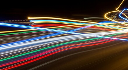Abstract long-exposure light trails in neon colors on a dark background. High-speed motion blur of colorful light streaks. Represents speed, fiber optics, data transfer, and nightlife energy.