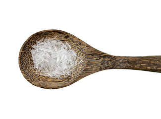 Menthol crystals are a purified, solid form of menthol, white crystalline shards on wood spoon indoors isolated on white background.