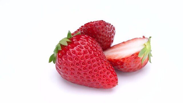 白背景で半分のイチゴと1つのイチゴがゆっくり回る4K動画