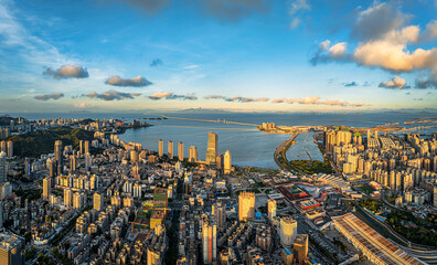 Aerial view of the modern cityscape of Zhuhai with the Hong Kong-Zhuhai-Macao Bridge during sunset in China.