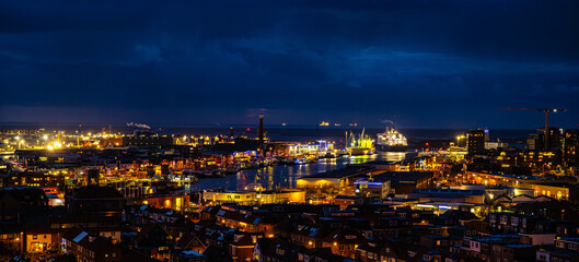 Fototapeta premium Ijmuiden Netherlands aerial view at night. Old dancing houses, canals, river channel and ships, canals with bridges, old european city landscape from above.