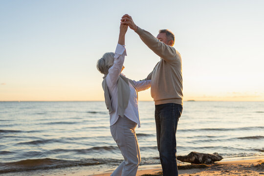 Keep moving. Romantic senior mature couple dancing together on beach outdoor recreation. Happy smiling family retired man woman husband wife having fun enjoying time together. Family moment love care