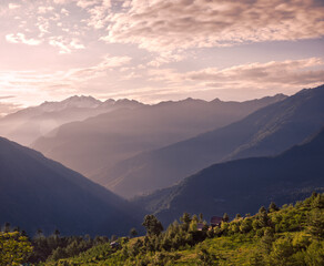 Obraz premium Mountain landscape with fog. Majestic Golden Hour Over Sainj Valley, Himachal Pradesh. This serene landscape showcases the majestic Himalayan peaks and traditional mountain scenery of Northern India.