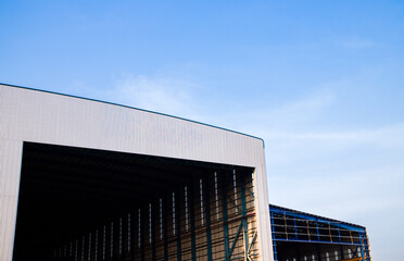 Warehouse exterior with loading ramps and slots for trucks to park - modern industry warehouse storage building.
