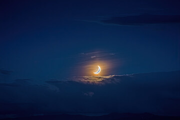 Sunset over the sea with the sun shining through soft clouds