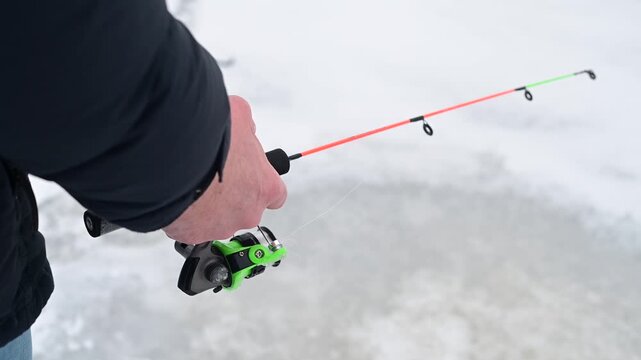 Man holding fishing rod ice fishing outdoor activity winter