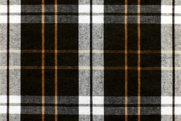 The texture of linen fabric in a large cage of brown, red and white. Scottish tailoring material. Checkered fabric