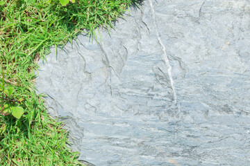 Naklejka premium Close-up view of granite laid on grass lawn, creating a natural
