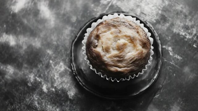 Single portion dessert in wrapper on black table.
