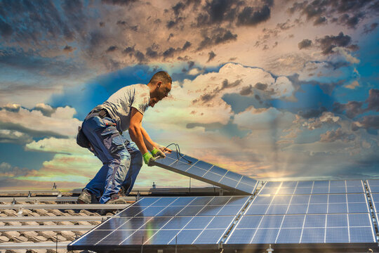 Installing solar photovoltaic panel system. Solar panel technician installing solar panels on roof. Alternative energy ecological concept.