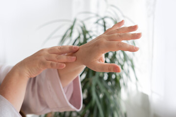 close-up hands elderly woman on light background, Aging and beauty, graceful wrinkles, Health and wellness, anti-aging cosmetology and care for aging skin