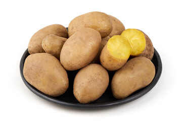 Potatoes on black plate, isolated on white background