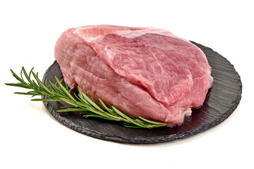 Raw pork loin roast sits on a black slate board with fresh rosemary, isolated on white background.
